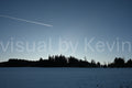 Winterfeld vor dunkler Waldsilhouette