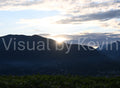 Sonne geht hinter Bergkamm unter