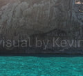 Klares Meer vor dunkler Grotte