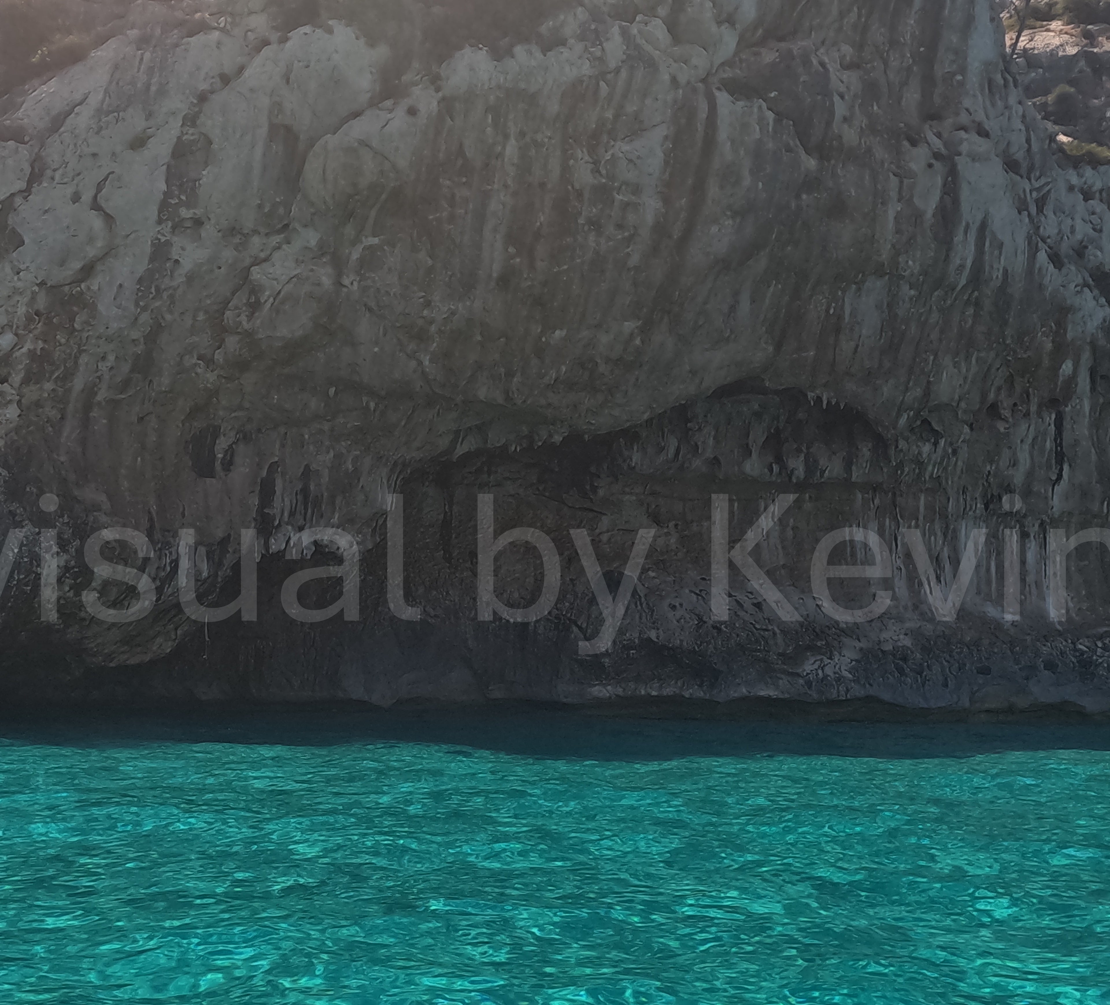 Clear sea in front of a dark grotto